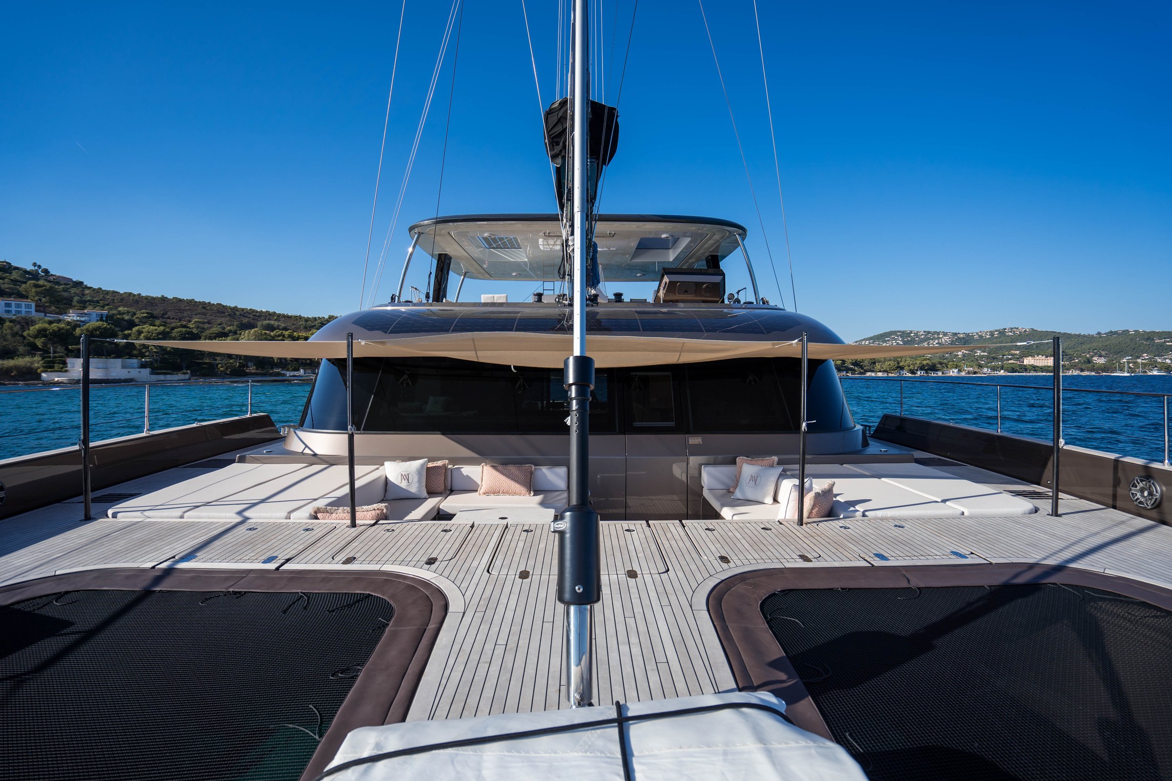 The teak foredeck of Āura, from the trampolines towards the lounge and flybridge