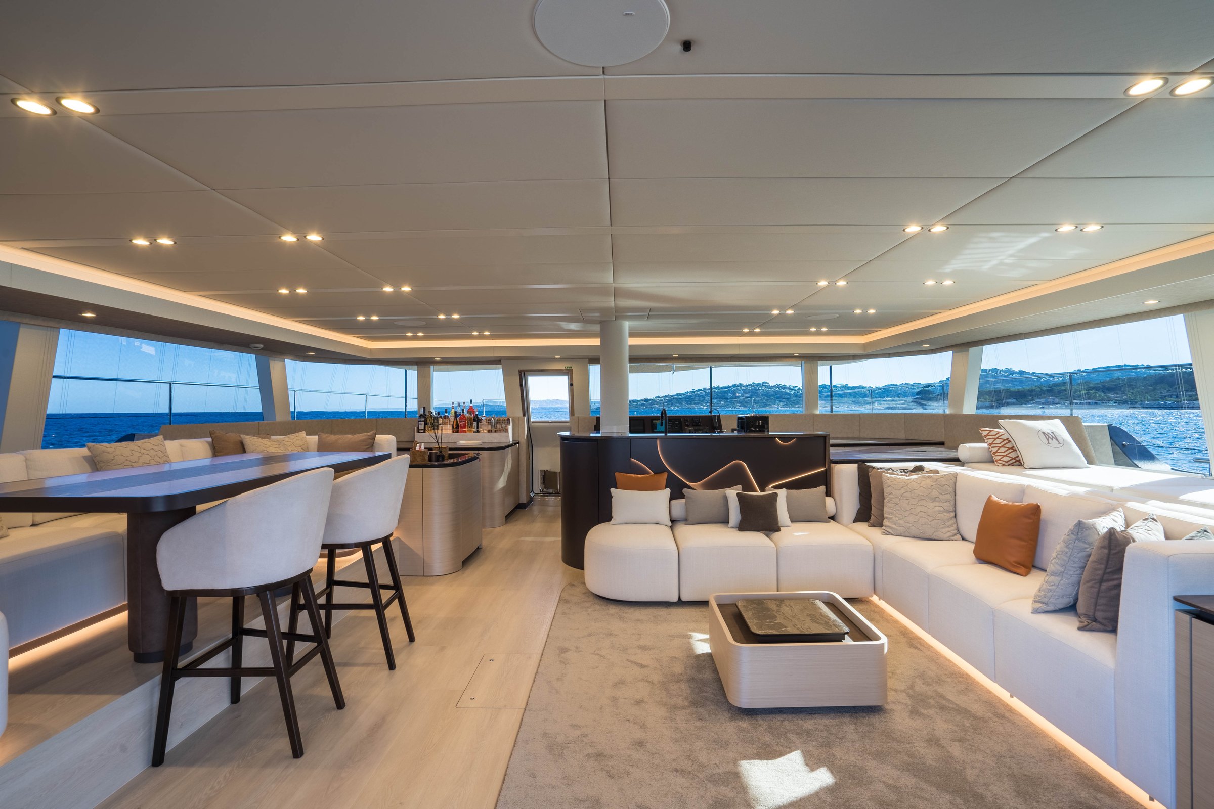 The main saloon of Āura, bar and lounge framed by panoramic windows