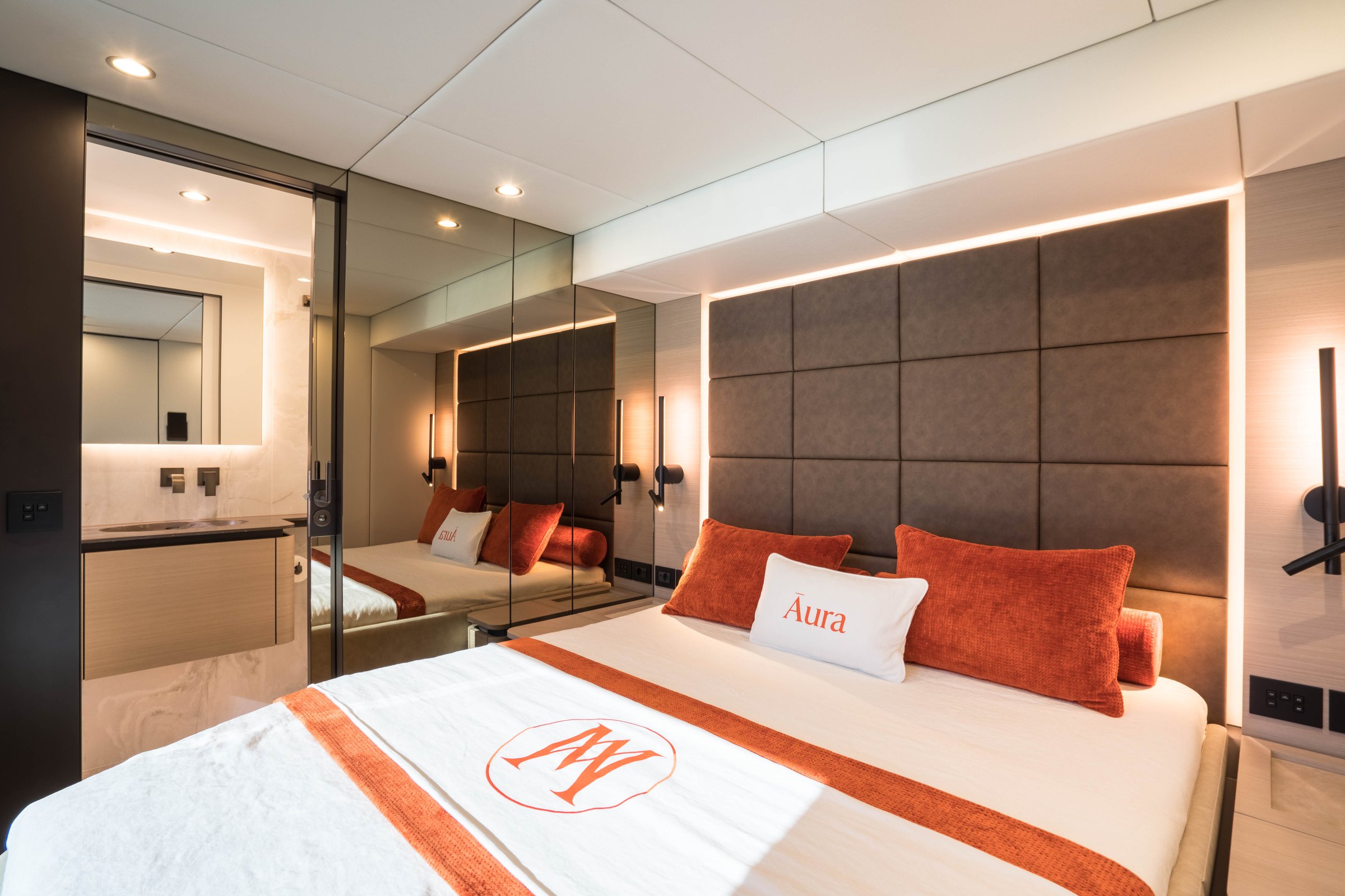 A guest cabin on Āura, padded headboard and linen embroidered with her name