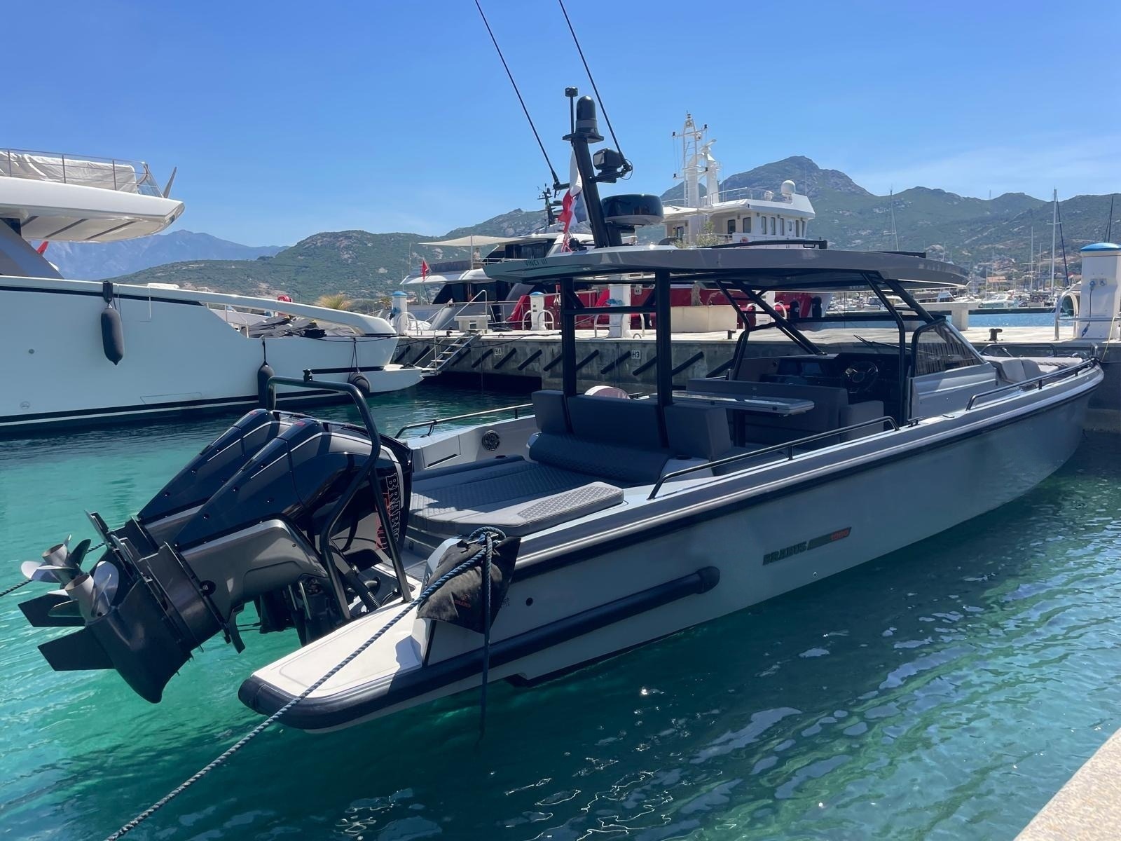 Vinci III from the stern quarter, her bathing platform and twin outboards tilted up, alongside