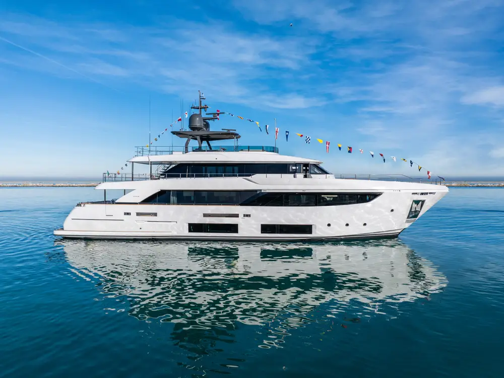Upstream, the 33 m Custom Line Navetta 33, in profile on calm water, dressed overall