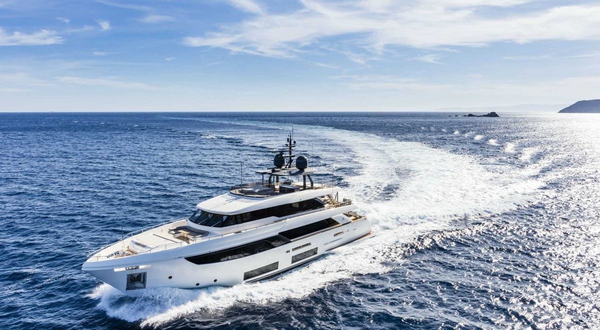Upstream, a Custom Line Navetta 33, under way off a rocky coast